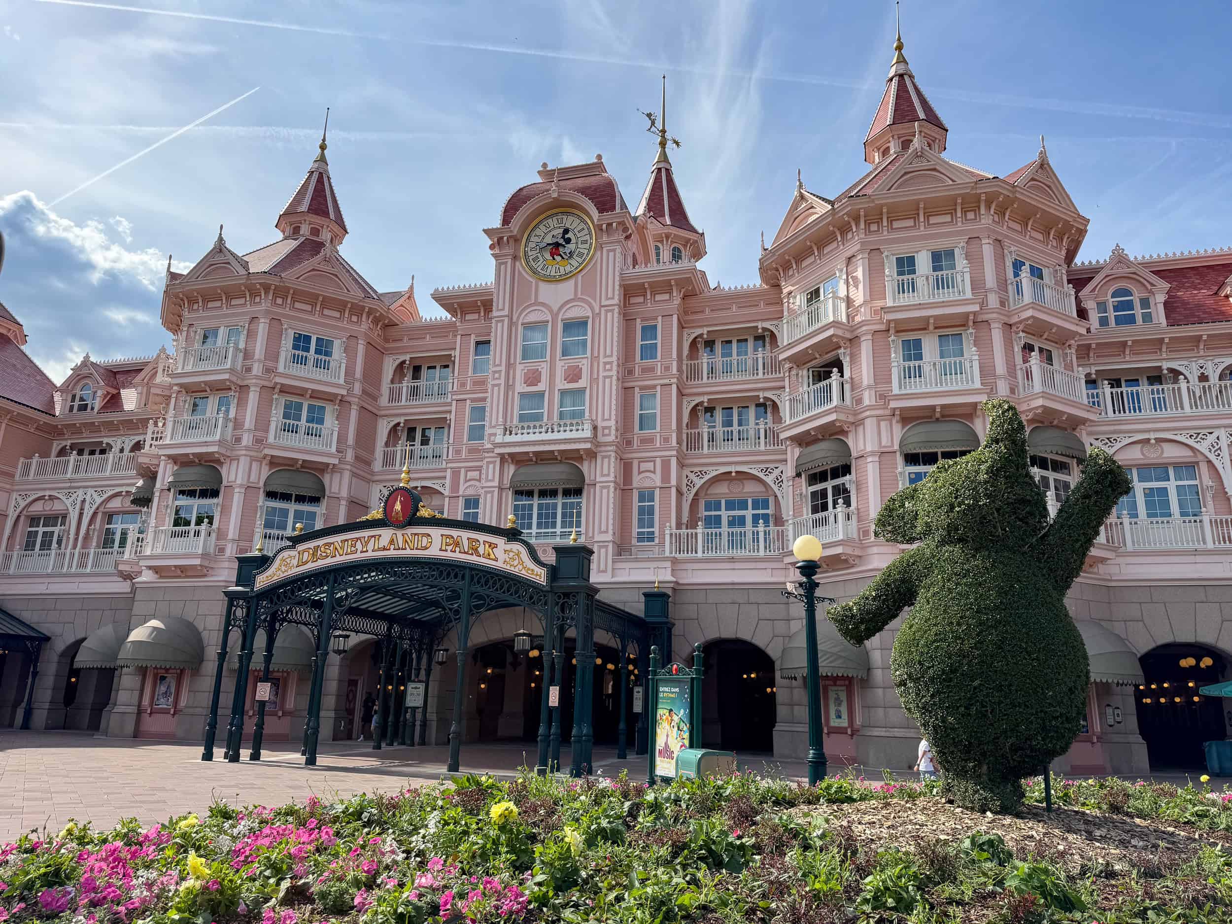 The Disneyland Hotel Paris and the entrance to Disneyland Park with its pink building and topiary.